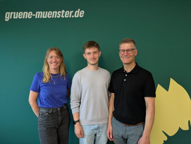 Familienfördergarantie Katharina Könning, Leon Herbstmann und Tilman Fuchs vor einer Grünen Pressewand